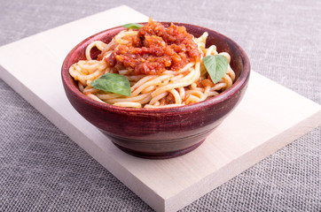 Cooked spaghetti in a brown small wooden bowl