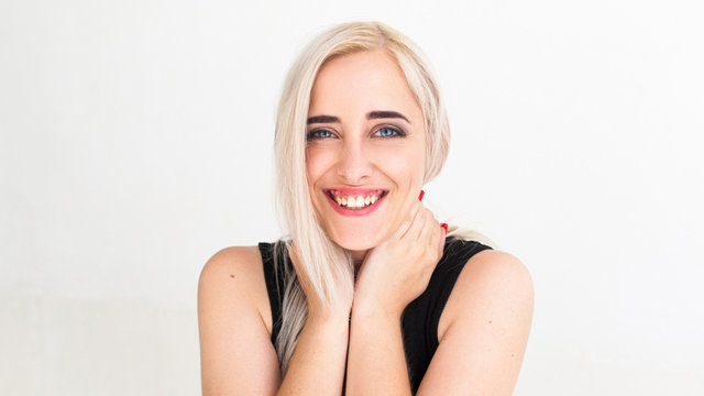 Widely smiling at camera pretty blonde. Lovely woman with strange smile hugging her neck and laughing, Happiness, fun, frivolity