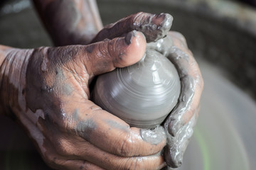 Hands working on pottery wheel