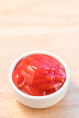 bowl of ketchup or tomato sauce on wooden table