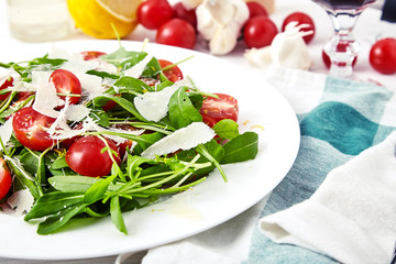 Fresh, summer salad with halves of cherry tomatoes and arugula