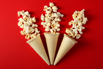 Popcorn in a waffle cone on a red background