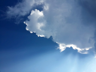 blue sky with clouds and rays of sunshine