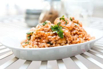 Tasty risotto with Shrimp, fresh herbs vegetables on a white pla