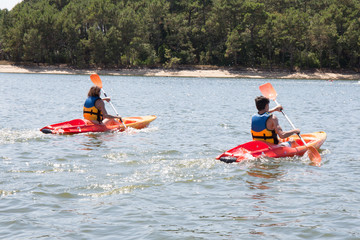 Two people travel the river on a kayaking in the summer.