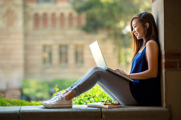 Bright youthful smart student studying cramming for exam with laptop computer