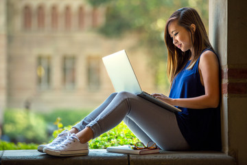 Young asian student on university campus with computer laptop 