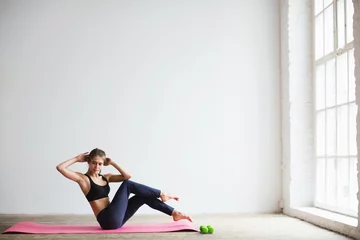 Foto op Plexiglas Portret van een jonge vrouw in sportkleding, die fitnessoefening doet. © BestForYou