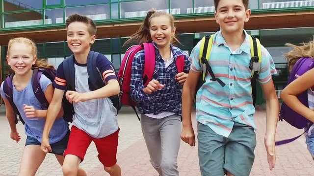 group of happy elementary school students running