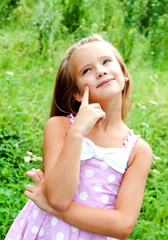 Portrait of adorable thinking little girl in summer day