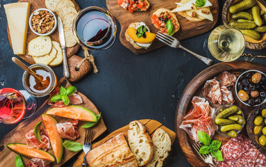 Italian wine antipasti snack variety over dark background, top view, copy space, horizontal composition