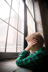 Little boy standing behind the window in sad mood. Sad Teenager looking in the Window and closing...