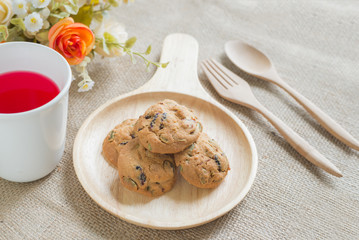 Oat cookies with pumpkin seeds and raisin on a wooden plate