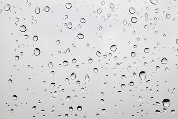 Photo of raindrops on a dusty glass.