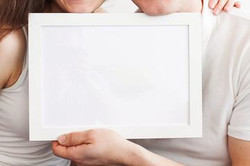 Hands of the man and the woman hold a frame with a clean sheet.