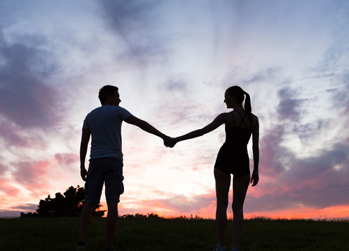Young couple holding hands outdoors.  People in love. 