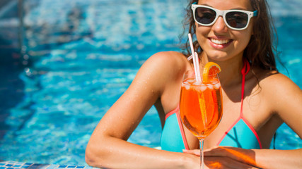 Beautiful women relaxing in swimming pool with cocktails