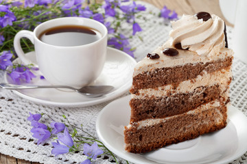 Tea, cake, wild flowers bells on the old table