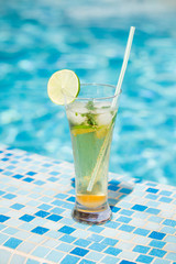Mojito cocktail with lime and mint in highball glass on tre beach background Copy space