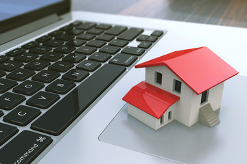 Small house on laptop keyboard. Real estate agency online. Conce