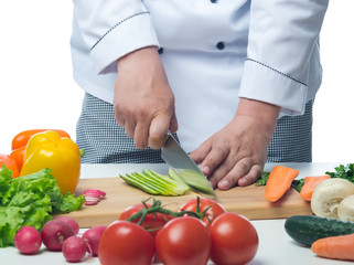Chef cuts the cucumber  on a board