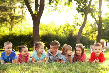 Fototapeta premium Happy kids lying on grass in park