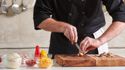 Restuarant hotel private chef cutting mushrooms on board