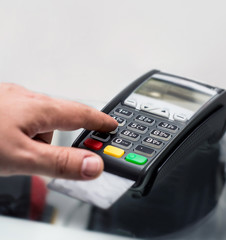 Credit or debit card password payment. Customer hand is entering pin