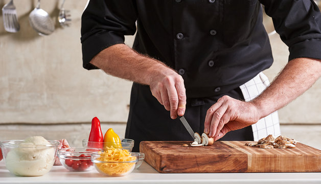 Restuarant hotel private chef cutting mushrooms on board