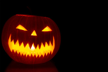 Carved Halloween pumpkin on dark background with copy space