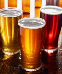 three different types of beer in glass mugs