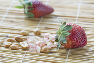 A fruit is strawberry and pomegranate,peanut on mat.