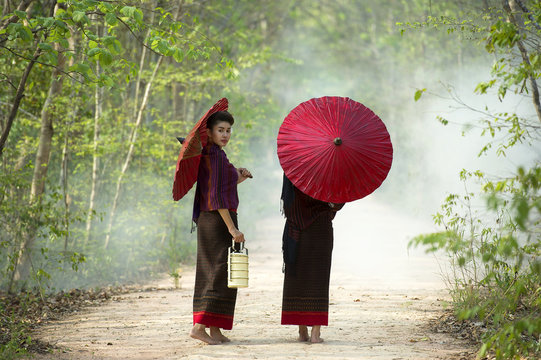 Two women walking holding red umbrella