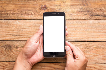 Top view hand using phone blank screen on the wooden table