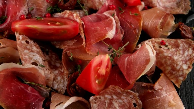 Delicious sliced ham, salami, bacon and tomatoes, closeup, loop