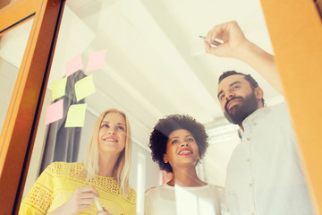 Fototapeta premium happy creative team writing on stickers at office