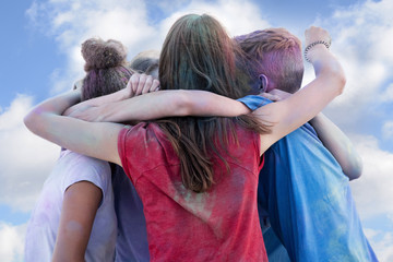 group of young teenager having fun on a holi festival and hugging as friends