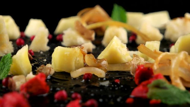 Delicious cheese platter on the black stone tray, closeup, loop