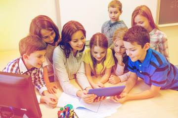 group of kids with teacher and tablet pc at school