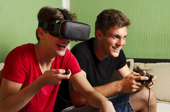 Brothers playing video games, one with Vr glasses