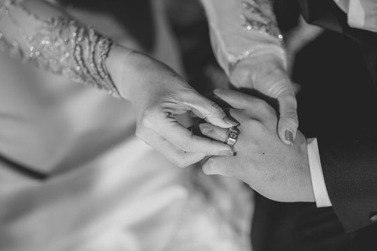 Newlyweds exchange rings, bride's hand putting a wedding ring on the groom's finger. Monotone image in black and white color. Ring wedding in Thai object. Monotone image in black and white color.