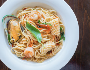 Spaghetti spicy with seafood on a white plate
