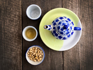 Tea pot and tea cup with soybean on wood table background textured.
