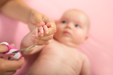 Obraz na płótnie Canvas Cutting baby nails, closeup