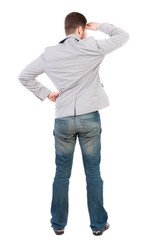 Fototapeta premium back view of Business man looks. Rear view people collection. backside view of person. Isolated over white background.A guy in a gray jacket looks afar having put his hand to his eyes.