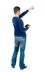Back view of pointing business man.  Rear view people collection.  backside view of person.  Isolated over white background. bearded man in blue pullover is holding tablet and shows a finger at the