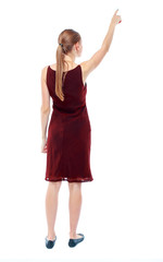 Back view of  pointing woman. beautiful girl. Rear view people collection.  backside view of person.  Isolated over white background. The girl in the maroon sleeveless dress shows a finger to the sky.