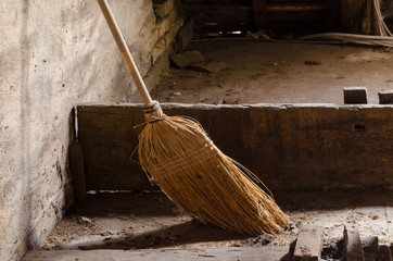 old broom in the dusty weathered room of a house