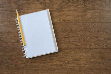 blank white notebook on wooden texture background