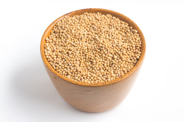 Mustard seeds into a bowl in white background